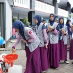 Penyerahan donasi jelantah oleh siswa untuk dijadikan biodiesel.